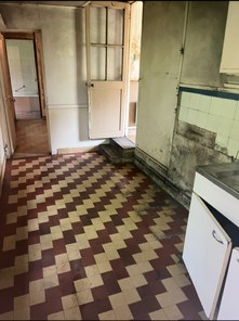 La même cuisine vidée, carrelage dégagé, après le débarras