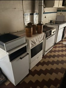 Cuisine ancienne encombrée de vieilles cuisinières et de meubles, avant le débarras